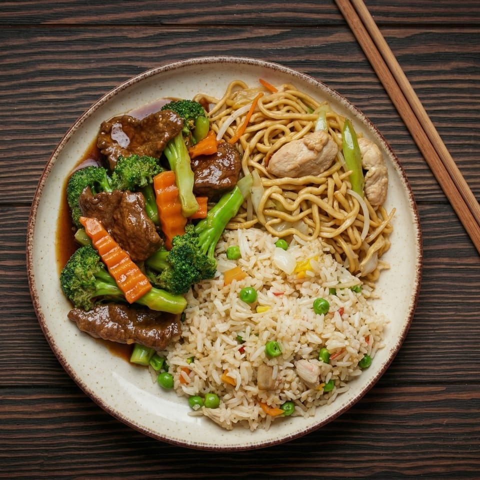 A plate of beef and broccoli, chicken lo mein, and fried rice with chopsticks on a wooden table.
